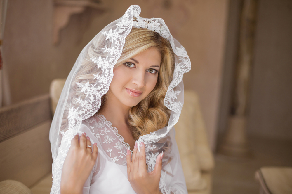 Beautiful smiling bride in wedding veil. Beauty portrait. Happy