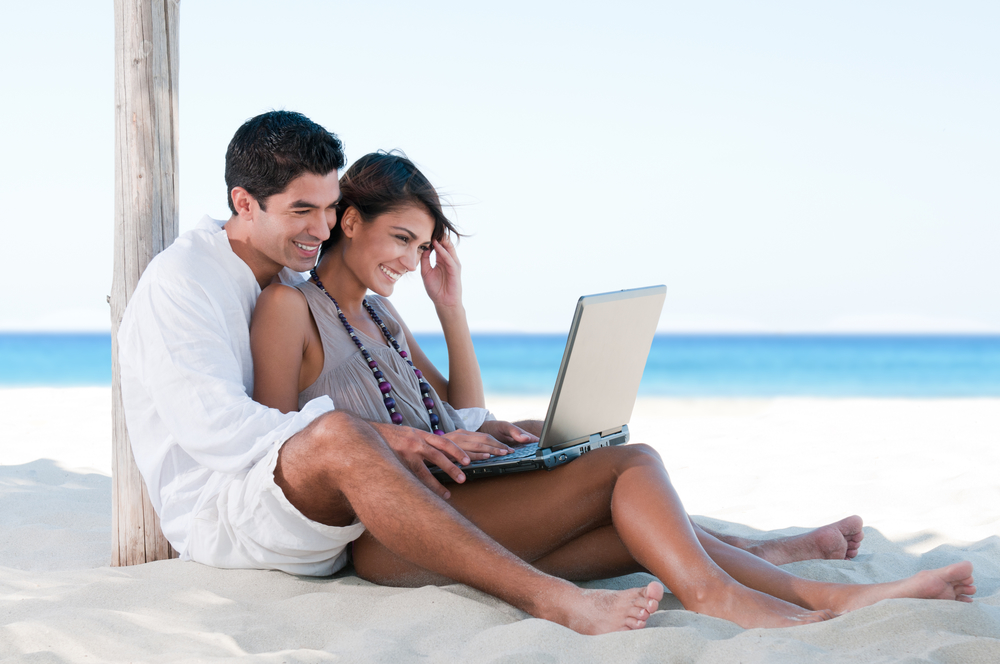 Happy smiling couple surfing the net and enjoy the summer at tropical beach