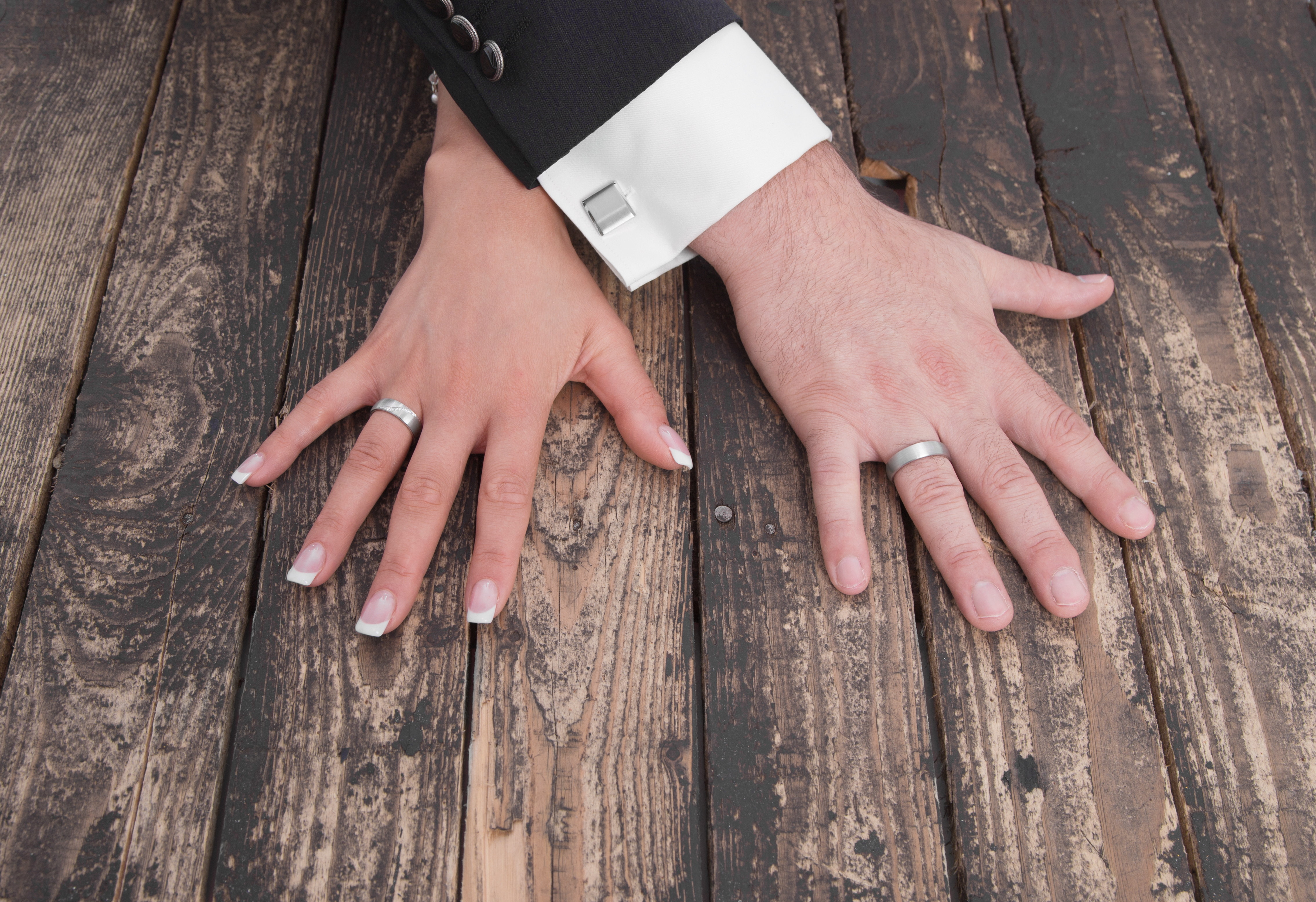 wedding theme, man and woman hands on a wooden floor
